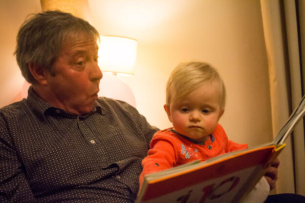 Ambre se fait lire un livre par papy